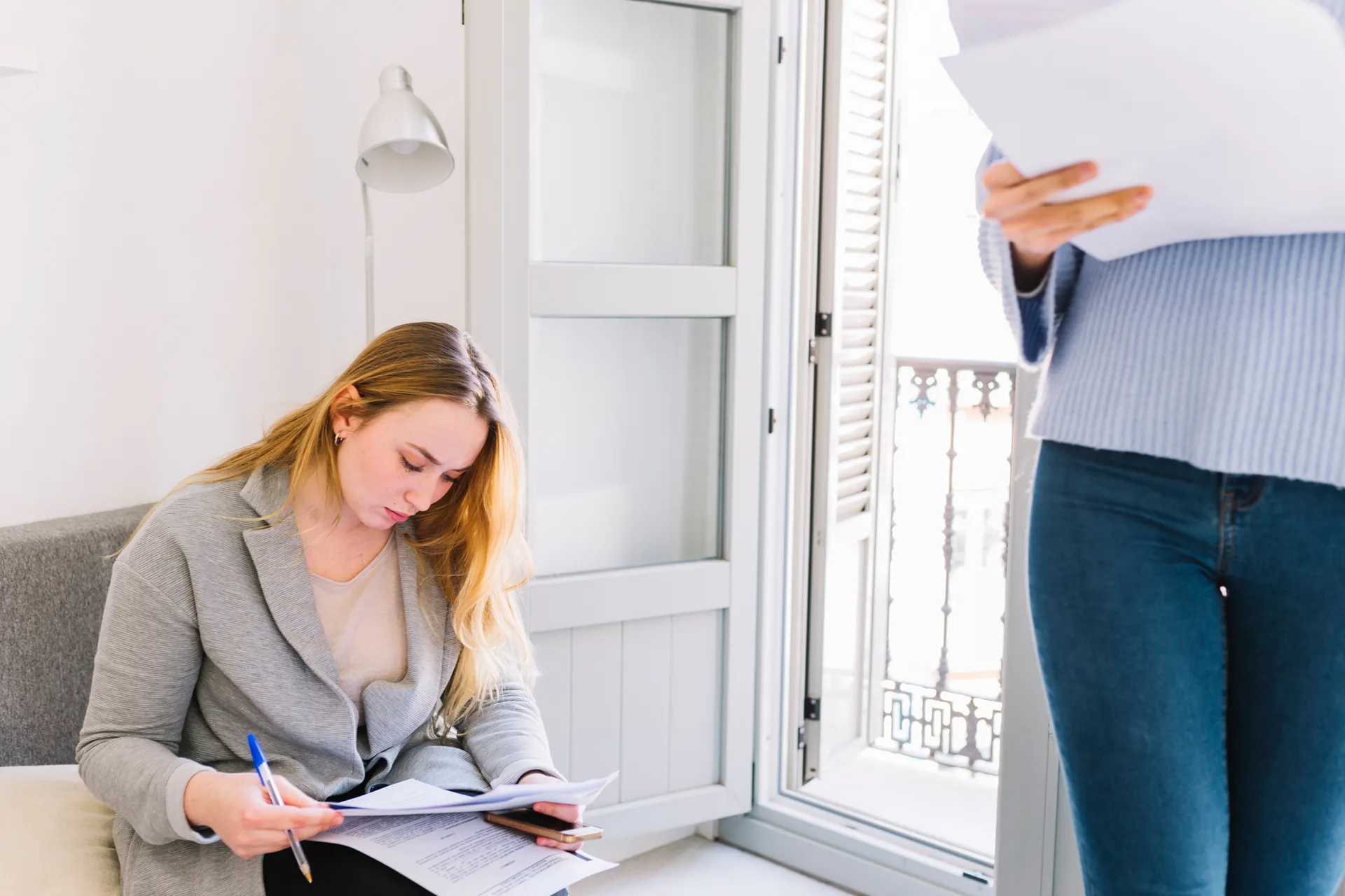 Woman signing documents in living room