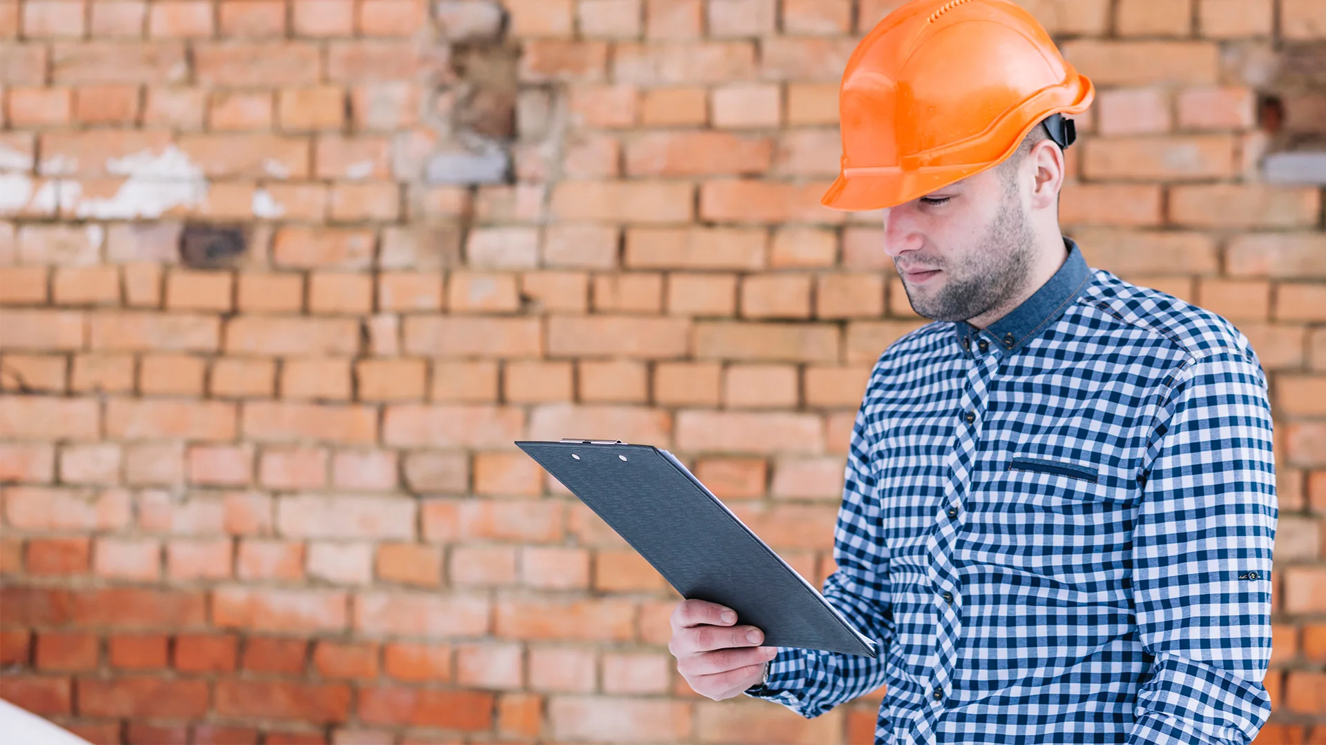 Architect in front of brick wall