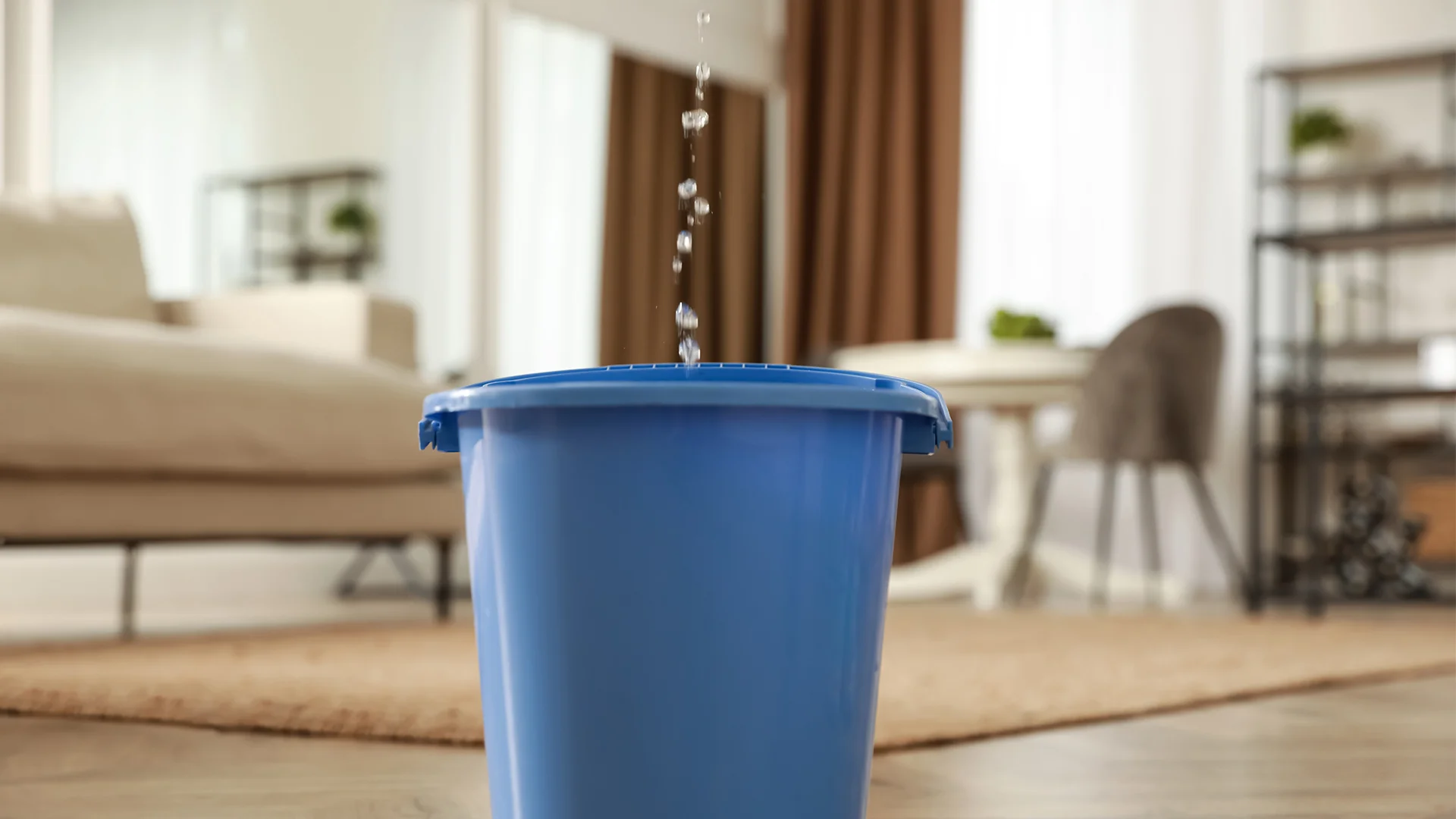 Bucket collecting water from ceiling