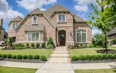 Newly constructed brick home with landscaped front yard, featuring a walkway leading to the entrance, highlighting property inspection focus.